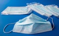 Used disposable and new in packaging medical mask on a blue background