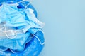 Used disposable surgical mask in a trash bucket on a blue background with copy space. Over of coronavirus quarantine Royalty Free Stock Photo