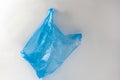 Used empty blue shopping bag being wrinkled and thrown in nature Royalty Free Stock Photo