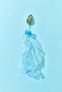 Used enpty plastic bottle with green leaf and shadows on blue. Royalty Free Stock Photo