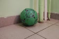 Used green soccer ball in entrance hall of a living block.