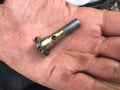 Used hydraulic bolt in dirty service man hand