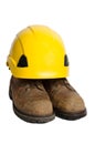 Used leather safety boots and yellow hard hat isolated Royalty Free Stock Photo