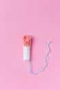 Used medical female tampon over a pink background. Menstruation, means of protection
