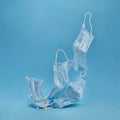 Used medical hygienic mask, face protective masks on blue background. Disposable surgical face mask protective against Coronovirus