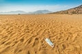 medical mask discarded on a sandy beach by the sea. The concept of irresponsible behavior and environmental pollution. Royalty Free Stock Photo