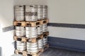 Used metal beer keg barrel on wooden pallets in corner of warehouse after delivery. Steel drink containers storage Royalty Free Stock Photo