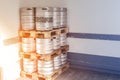 Used metal beer keg barrel on wooden pallets in corner of warehouse after delivery. Steel drink containers storage Royalty Free Stock Photo