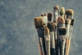 Used paint brushes on a gray background. A bunch of brushes for painting with oil and acrylic paints. Royalty Free Stock Photo