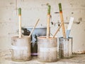 Used paint buckets and brushes in front of a stained wall Royalty Free Stock Photo