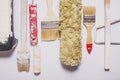 Used painting tools with red handles covered in warm white paint Royalty Free Stock Photo