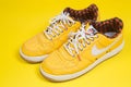 Used pair of Yellow Nike Air Force sneakers on yellow background
