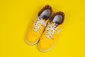 Used pair of Yellow Nike Air Force sneakers on yellow background