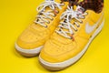 Used pair of Yellow Nike Air Force sneakers on yellow background