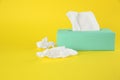 Used paper tissues and box on yellow background Royalty Free Stock Photo