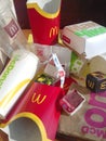 Used paper wrappings and disposable packs with McDonalds design and logo in pile on table. McDonalds recycle trash after usage