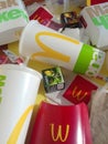 Used paper wrappings and disposable packs with McDonalds design and logo in pile on table. McDonalds recycle trash after usage
