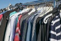 Used second hand clothes on hangers on a garment rack, as donation to a charity or for flea market sale, selected focus