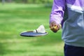 used shuttlecock in badminton racket holding by a man in the park Royalty Free Stock Photo