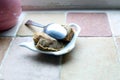 Used teabags on a teabag shaped plate, and a dirty spoon, on a kitchen windowsill Royalty Free Stock Photo