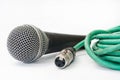 Used vocal microphone with old green xlr cable on the white back Royalty Free Stock Photo