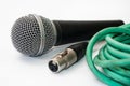 Used vocal microphone with old green xlr cable on the white back Royalty Free Stock Photo