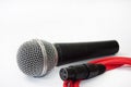 Used vocal microphone with red xlr cable on the white background Royalty Free Stock Photo