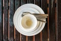 Used white bowl and plate with fork and spoon on wooden table Royalty Free Stock Photo