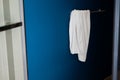 Used white towel hangs on blue wall in bathroom Royalty Free Stock Photo