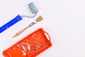 Used wooden paintbrush, red paint tray and paint roller on side of light background with copy space Royalty Free Stock Photo