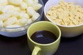Useful breakfast. Corn sticks flakes in a container and a mug of coffee. On a dark background. Royalty Free Stock Photo