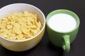 Useful breakfast. Corn sticks flakes in a container and a mug of milk. On a dark background. Royalty Free Stock Photo