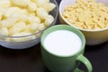 Useful breakfast. Corn sticks flakes in a container and a mug of milk. On a dark background. Royalty Free Stock Photo