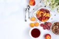 Useful breakfast, food for children, fruit salad with peaches, pears, granola, grapes and flower tea on a bright table. The Royalty Free Stock Photo