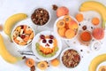 Useful breakfast with ingredients, food for children, fruit salad with granola, apricots, bananas, honey and peaches on a bright Royalty Free Stock Photo