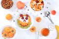 Useful breakfast with ingredients, food for children, fruit salad with granola, apricots, bananas, honey and peaches on a bright Royalty Free Stock Photo