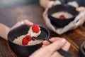 Useful breakfast of porridge with blueberries and fresh raspberries. Still life on a wooden background with hands. Royalty Free Stock Photo