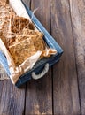 Useful dietary grain loaves rye, buckwheat, wheat in an old wooden box on a wooden background.vertical version