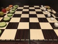 Useful and harmful foods play chess. Junk foods vs Vegetables