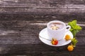 Useful light breakfast snack. Fresh herbal fruit tea with berries and leaves north cloudberries in a white ceramic cup Royalty Free Stock Photo