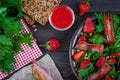 Useful strawberry salad with arugula, nuts and bacon, berry sauce