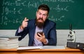 User experience. School teacher hold mobile phone chalkboard background. Teacher bearded man learn use modern technology