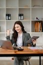 usiness woman are delighted and happy with the work they do on their tablet, laptop and taking notes at the modern office