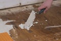 using a angled trowel to dollop cement on subflooring