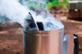 Using barbecue chimney starter to get charcoal ready for cooking on grill Royalty Free Stock Photo