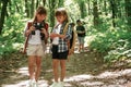 Using binoculars. Kids in forest at summer daytime together Royalty Free Stock Photo
