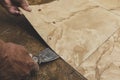 Using a blade scrapper or putty knife to remove old vinyl tiles from the floor. Home renovation concept