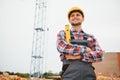 Using bricks. Young construction worker in uniform is busy at the unfinished building Royalty Free Stock Photo