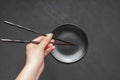 Using chopsticks over a an empty black plate Royalty Free Stock Photo