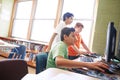 Using computers from an early age have several advantages. elementary children working on computers at school. Royalty Free Stock Photo